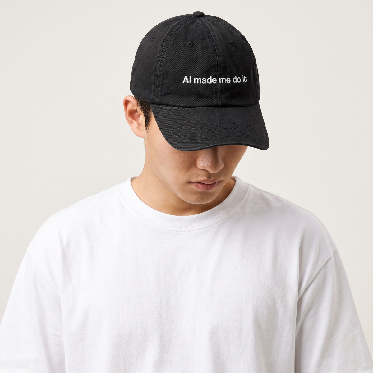 Model in a white tee wearing The HeadCount AI Made Me Do It black cap, head tilted down