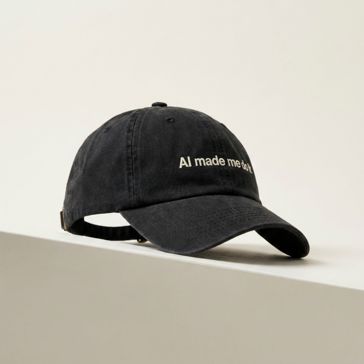 AI Made Me Do It black dad cap resting on a cream concrete ledge in daylight