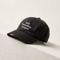 B2B Marketing Insights black dad cap resting on a cream concrete ledge in daylight