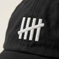 Close-up of The HeadCount tally mark logo embroidered in white on black cotton