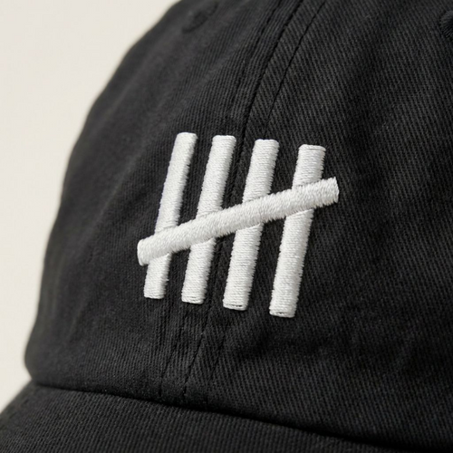 Close-up of The HeadCount tally mark logo embroidered in white on black cotton
