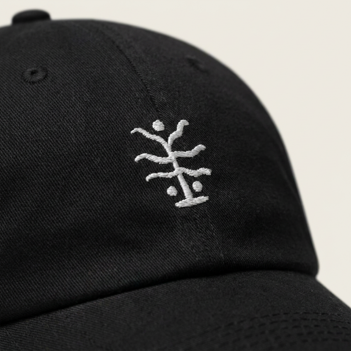 Close-up of the white seaweed embroidery stitched on washed black cotton