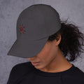Model wearing the dark grey Sun Cap with terracotta sun embroidery, left side view